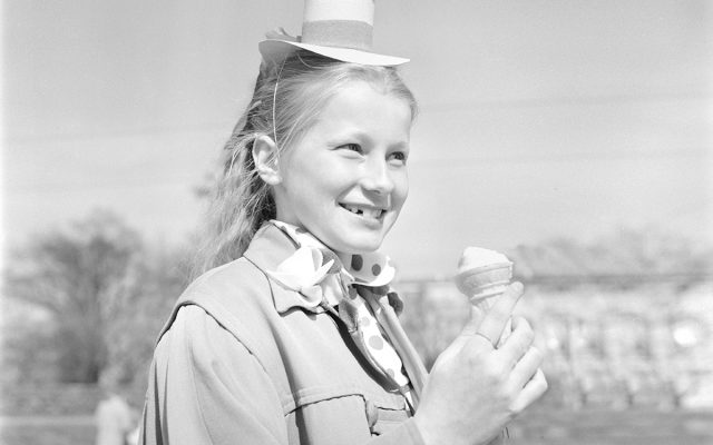 Kesäisessä kuvassa tyttö syö jäätelöä hymyillen ohi kamerasta. Kuvan on ottanut István Rácz ja se kuuluu Kansatieteen kuvakokoelmaan, Museovirastolle.