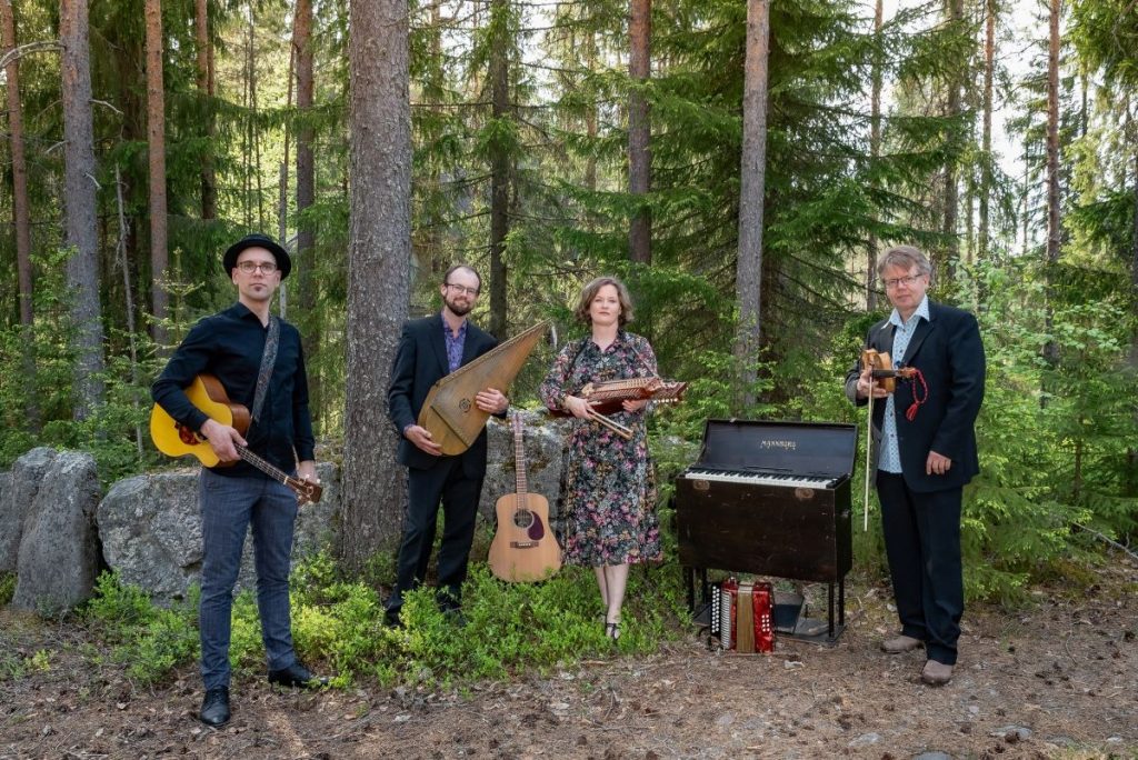 Tallarit-yhtyeen neljä jäsentä soittimineen metsässä